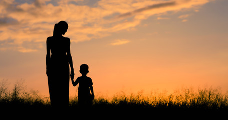 Mother son walking together holding hands. Motherhood, childhood, and family lifestyle concept. 
