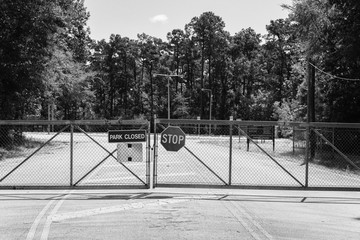 Filtered image gate closed at the entrance to park and nature preserve in suburban Houston, Texas,...