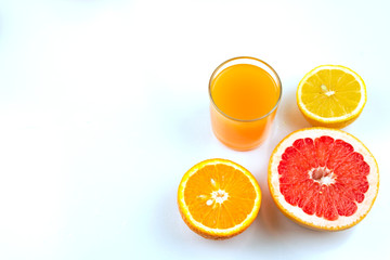 freshly squeezed citrus juice, a glass of fresh and half an orange, grapefruit and lemon, healthy vitamin lemonade. Isolate on a white background with place for text