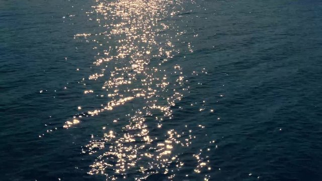 helles sonniges Funkeln auf der Wasseroberfl&auml;che und Wellen im Abendlicht.
