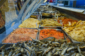 smoked and dried fish on the counter in the store, squid, herring, yellow whale