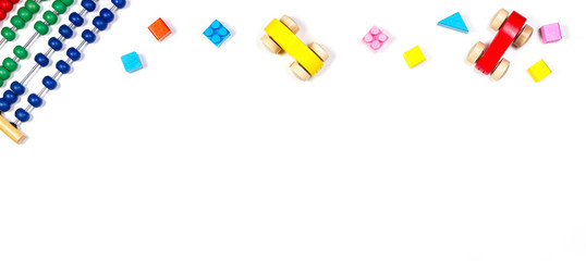 Baby kids toys banner background. Toy abacus, wooden cars and bricks on white background. Top view, flat lay