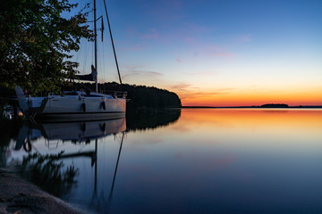 Żaglówka na jeziorze o zachodzie słońca