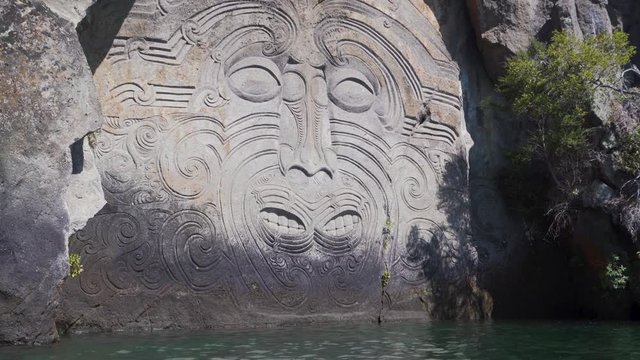 Moving Shot from Water, Maori Carving on Rock, Lake Taupo, New Zealand