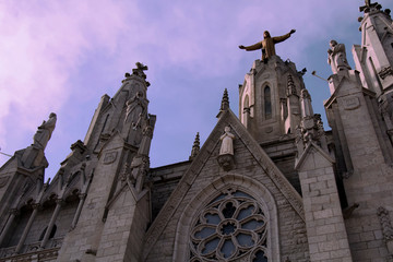 Fototapeta premium Vista en contrapicado de la Catedral del Monte Tibidabo ubicada en Barcelona, España. Cielo en tonos purpuras por detrás.