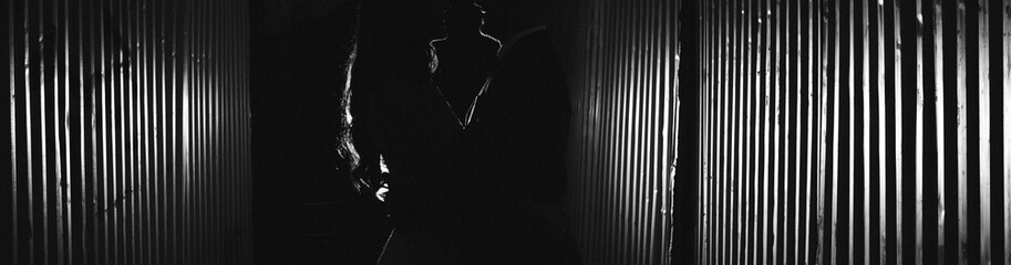 Silhouettes of a man and a woman in the dark