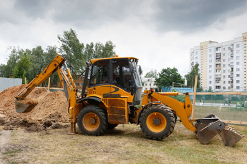 Excavator digs a trench. Side view.