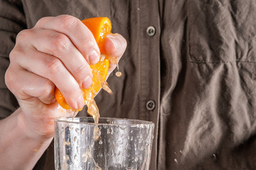 Woman making orange juice at home. Preparation of orange juice. Health concept. Soft focus
