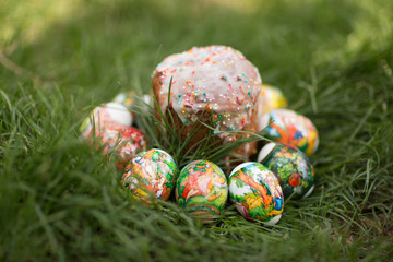  Easter bread and eggs with different patterns on green grass.