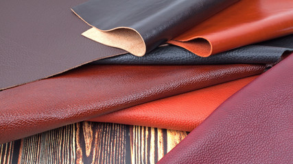 Natural leather textures samples on dark wooden background