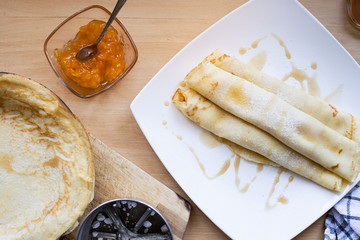 Pancakes rolled into a roll with jam and powdered sugar, top view