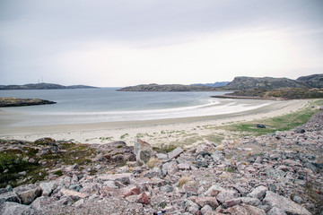 Panoramic view of the sandy beach and the sea. Summer on the Barents Sea.