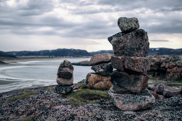 Stone pyramids on a rocky seashore. Kola Peninsula Arctic Circle. Shore of the Barents Sea.