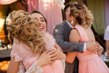 Happy momemt of wedding day. Bridesmaids congratulate the bride and groom after wedding ceremony