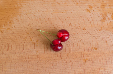 Ugly organic fruits - sweet cherries on a brown board. Trends. Ugly food. Copy space. Horizontal...