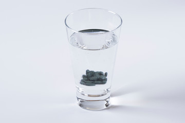 Gray Pills and water glass.