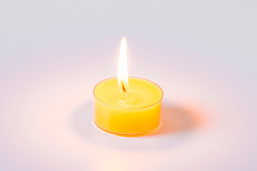 Small yellow candle on a white background.
