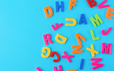 plastic multi-colored letters of the English alphabet on a bluet background