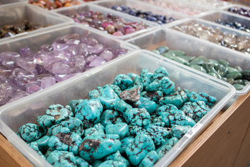 Polished natural stones of different colors and varieties are in the boxes.