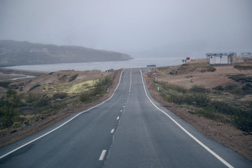 View of the road to the sea in foggy weather. Kola Peninsula of the Barents Sea.