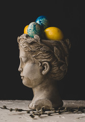 Vase in the form of an antique statue with Easter painted eggs