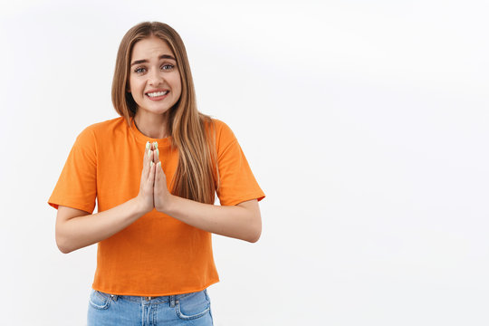 Portrait Of Cute Silly Girl Need Help Asap, Clench Teeth Making Pleading Smile, Hold Hands Together In Pray Say Please, Begging Favor, Lending Money From Friend, Asking Something, White Background