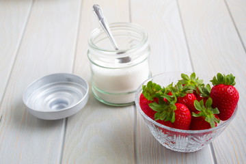 delicious red strawberries next to bowl with sugar and a spoon