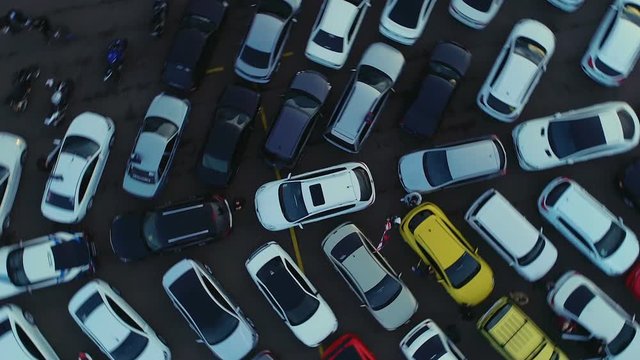 A Helicopter Circles Over Multicolored Cars