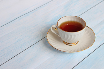 Top view of a cup of tea with tea bag on blue wooden table