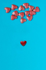 Pink and red small hearts on blue background. Abstract love, Valentine`s Day concept.