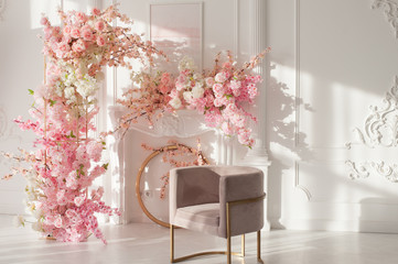 white interior with pink flowers and a chair