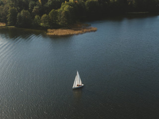 Aerial drone photo of small yacht sailing on lake Ukiel in Olsztyn, Masurian Lake District. 