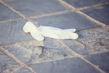 Used medical glove on the ground. Environmental pollution concept
