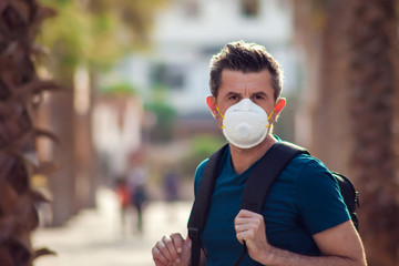 A portrait of man with face medical mask outdoor. Virus protection concept