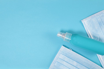 Fototapeta na wymiar Plastic bottle and medical masks on a blue background.