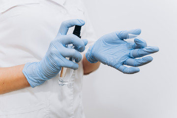 Obraz premium Doctor protective mask with antiseptic spray.Doctor holding a bottle of antiseptic. Infectious dangerous. Glove protection. Working hospital. Medicine concept. Virus. 