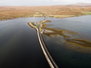 erial drone photo of the road dividing Kyle of Tongue which is a shallow sea loch in northwest Highland, Scotland, in the western part of Sutherlan. 