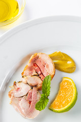 Stuffed chicken rolls on a white plate with mustard