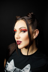 Fashion beauty portrait of a beautiful young girl. Makeup cat. Sexy woman with koshachmi ears on the hair. Face of the beautiful woman with long brown hair posing at studio over dark background.