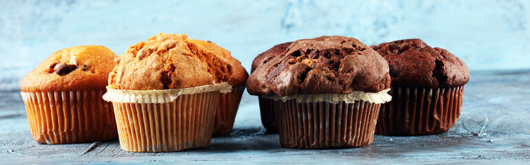Chocolate muffin and nut muffin, homemade bakery on background.