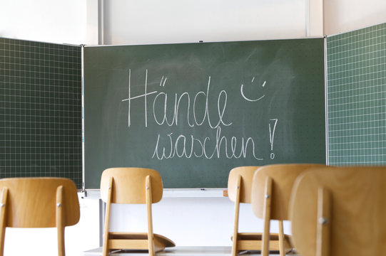 Schultafel in einem Klassenraum mit der Botschaft Hände waschen