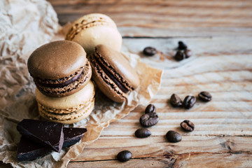 Fototapeta na wymiar Macarons au chocolat et café sur une planche en bois