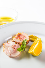Stuffed chicken rolls on a white plate with mustard