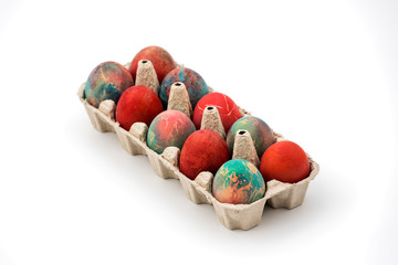 Colorful Easter eggs in cardboard egg box on white background. Raw chicken eggs in open egg box on a white background. Eggs in the package.