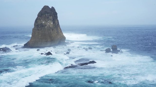 Beautiful aerial view of Papuma beach with frothy waves and coral background, Jember, East Java, Indonesia. Shot in 4k resolution