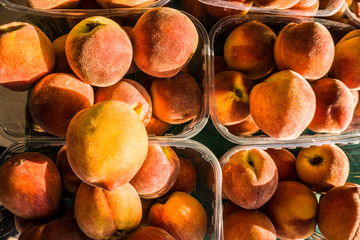 Closeup of a pile of beautiful delicious tasty orange peaches on the market bench or counter. Agricultural background concept photo. Desktop wallpaper. Overhead view.