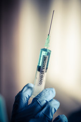 Hand holding a syringe with the coronavirus COVID-19 vaccine