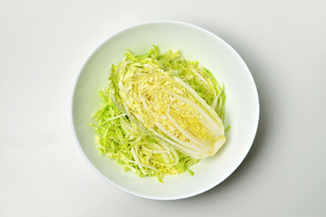 Chinese cabbage salad in white bowl over white. Vegan food lifestyle concept.