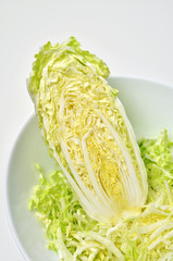 Chinese cabbage salad in bowl on white table background. Vegan food.
