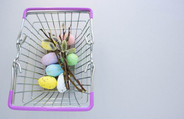 willow twigs and colorful eggs in a grocery basket. easter concept